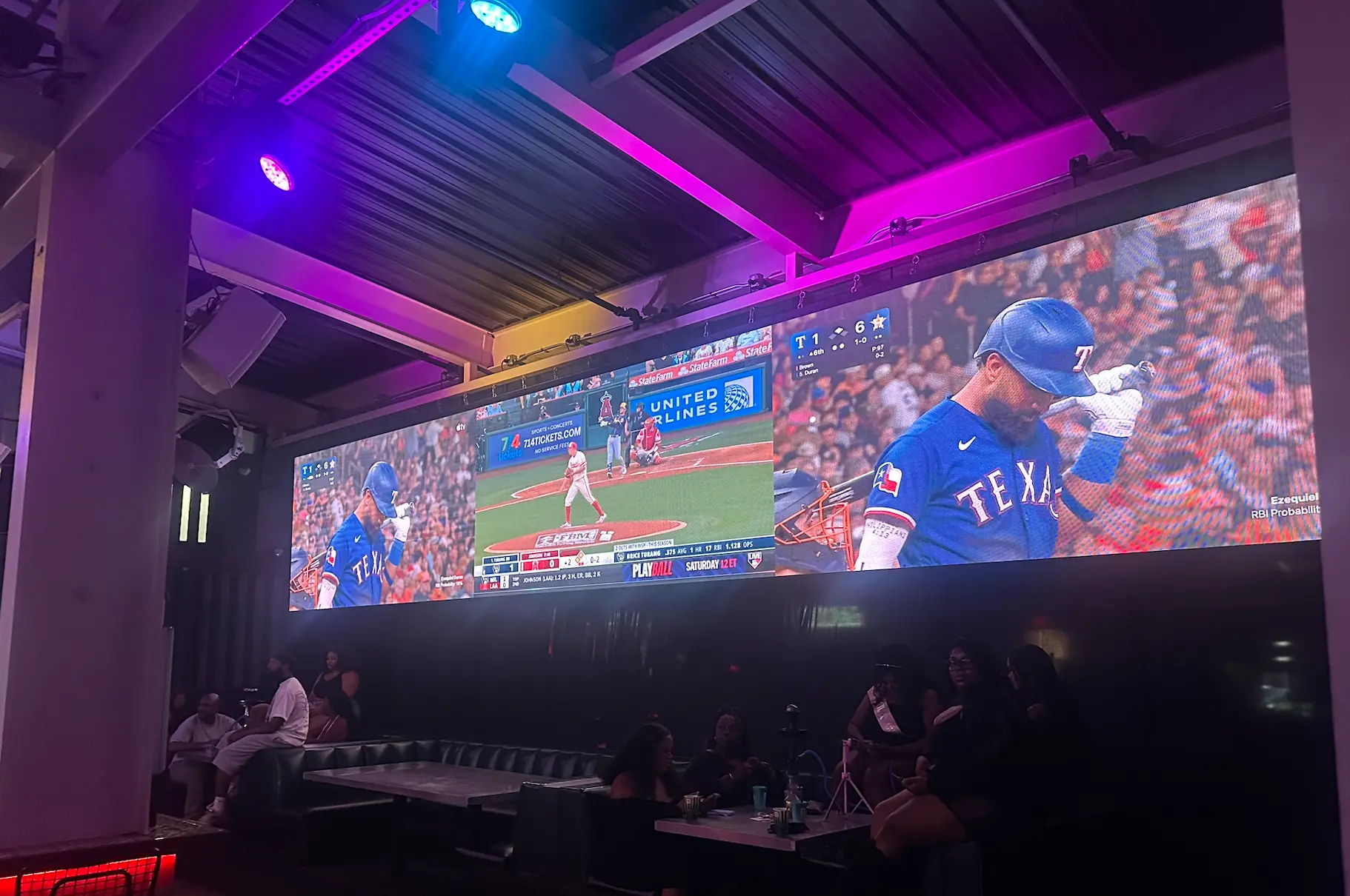 The big-screen wall and booth seating in the lounge at Sporting Club.